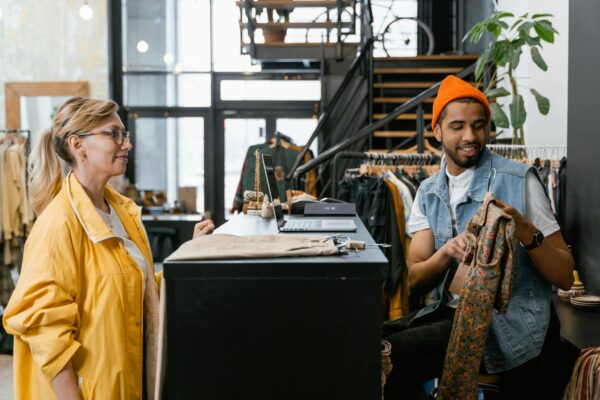 Two young adults interacting at a fashionable boutique, emphasizing style and shopping.